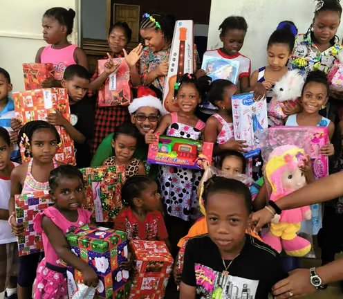 Smiling children holding gifts at a Christmas outreach